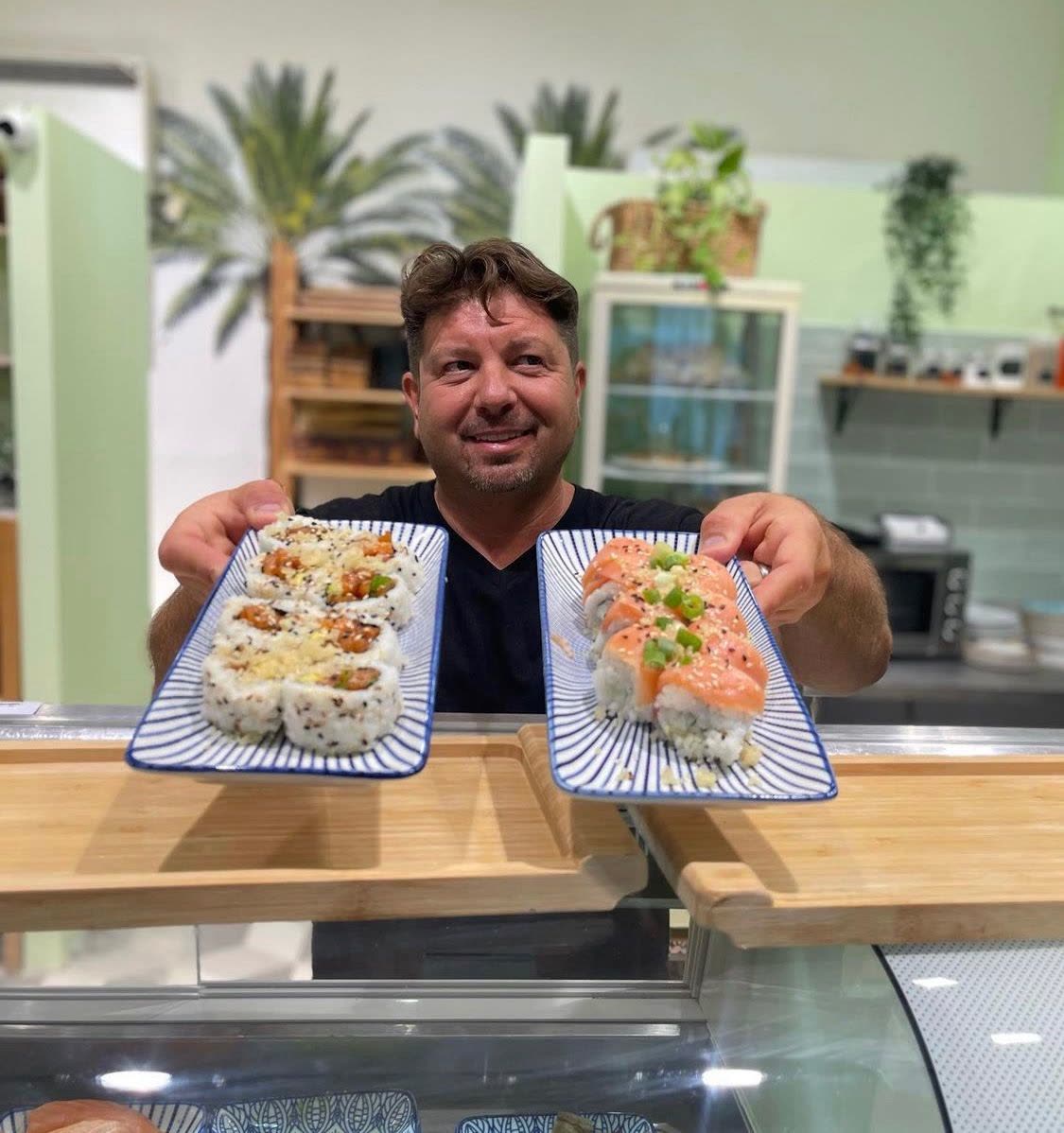 צביקה מגיש צלחות רולים מעל מקרר התצוגה